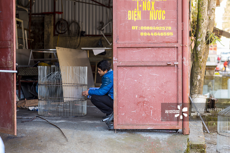 铁匠用铁丝制作鸟笼图片素材