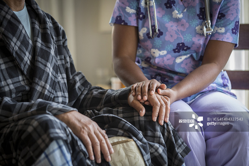 非裔美国人护士握着病人的手图片素材