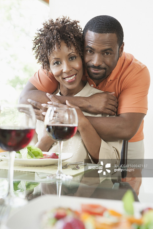 在餐桌旁拥抱的非裔美国夫妇图片素材