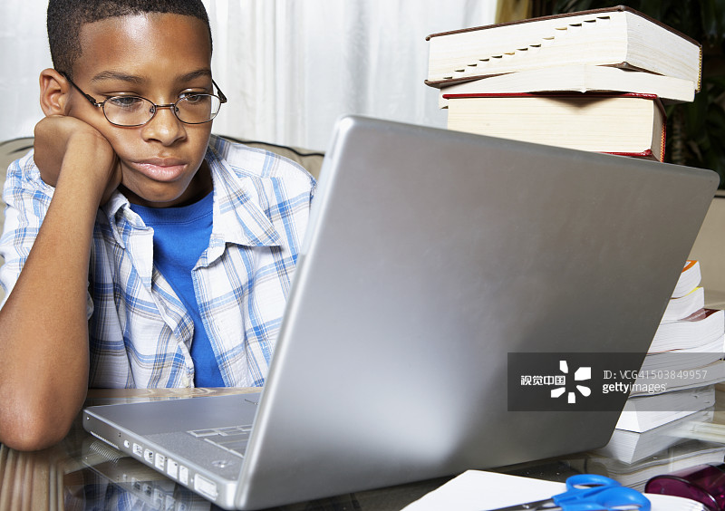 混血男孩使用笔记本电脑图片素材