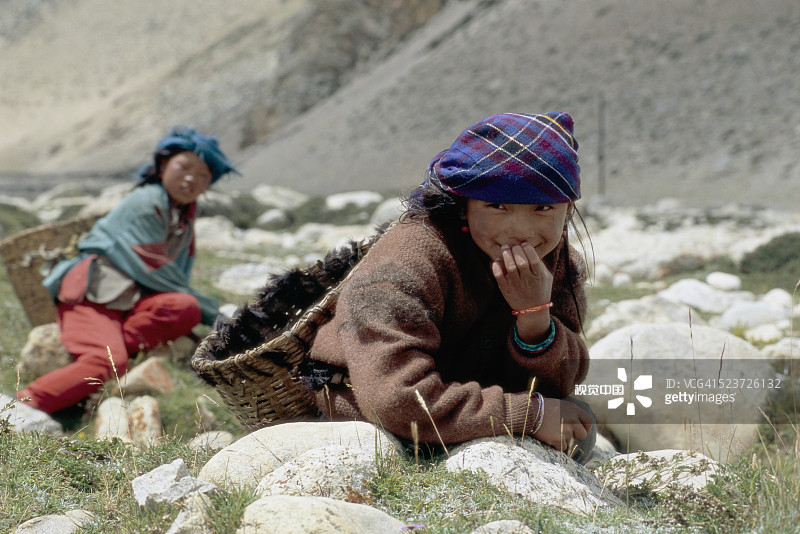 两名藏族女孩在聂拉木附近捡拾牦牛粪图片素材