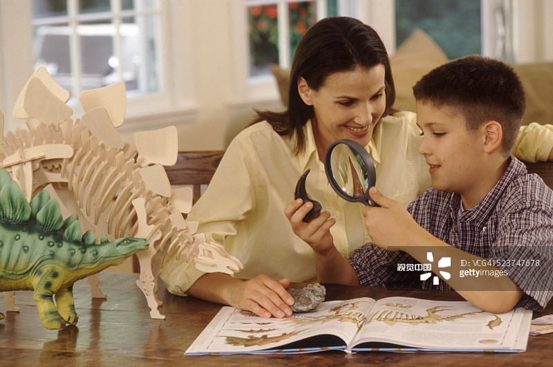 母亲和儿子一起学习恐龙图片素材