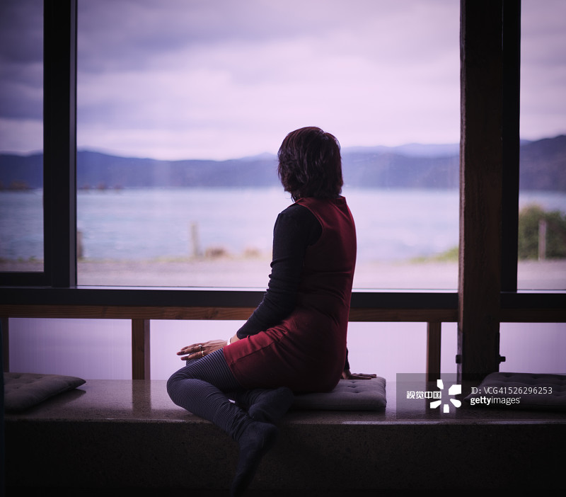 眺望现代住宅窗外的混血女人图片素材