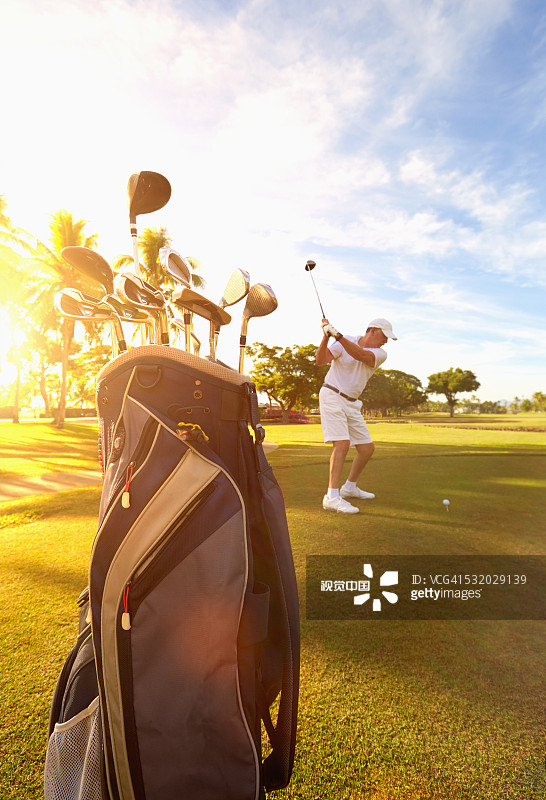 在golf球场上击球的白人golf球手图片素材