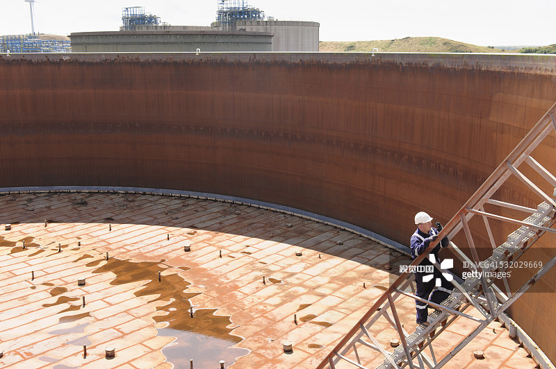 白种工人从燃料储罐中爬出来图片素材