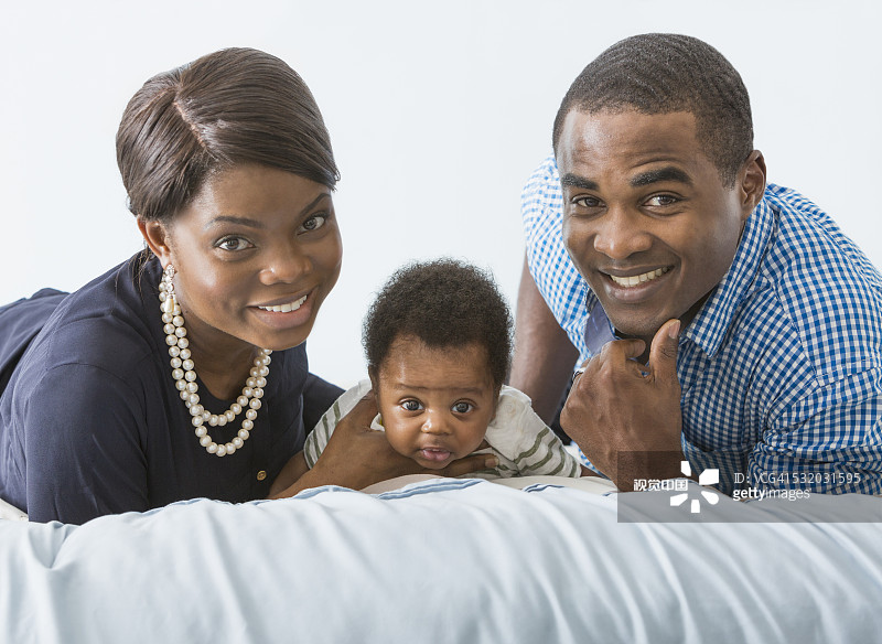 夫妇与儿子在床上微笑图片素材