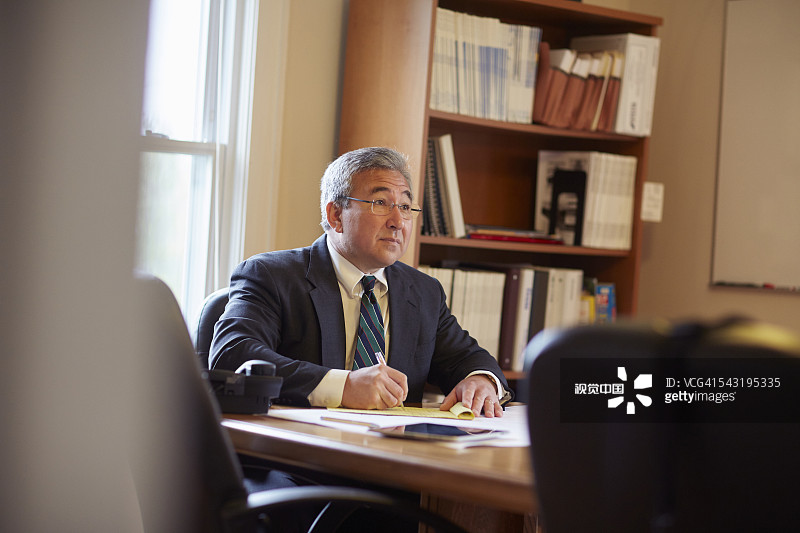 在办公室书桌前写作的商人图片素材