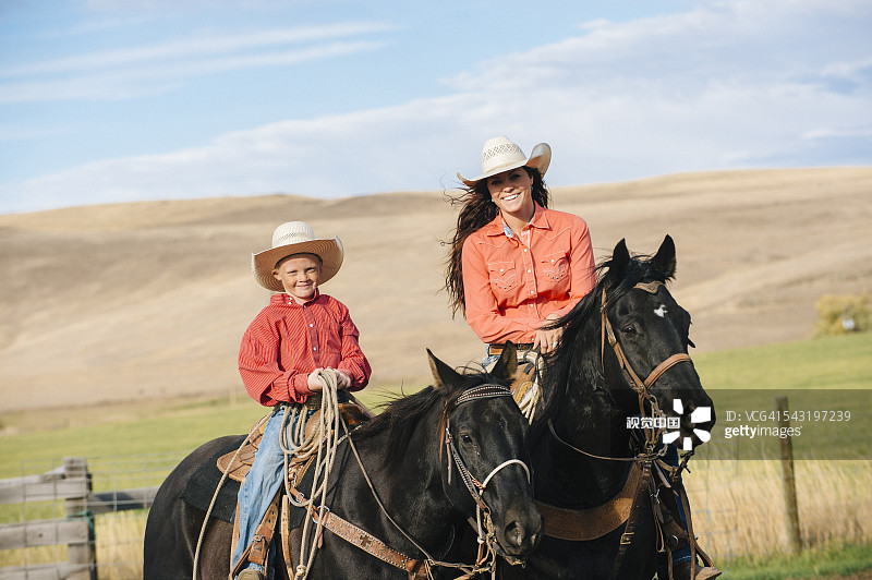 白人母子在草山上骑马图片素材