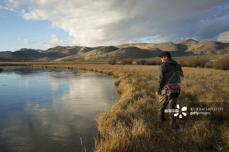 一名男子在河边搬运渔具图片素材