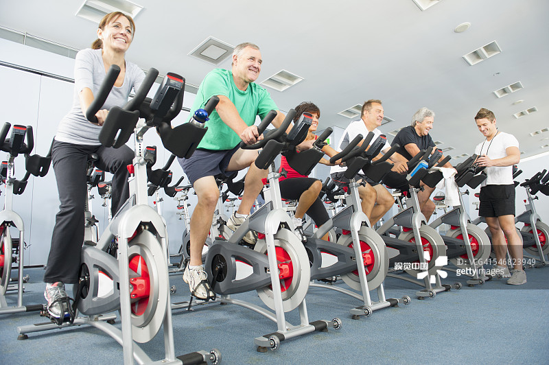 低角度拍摄在健身房里骑动感单车的人们图片素材