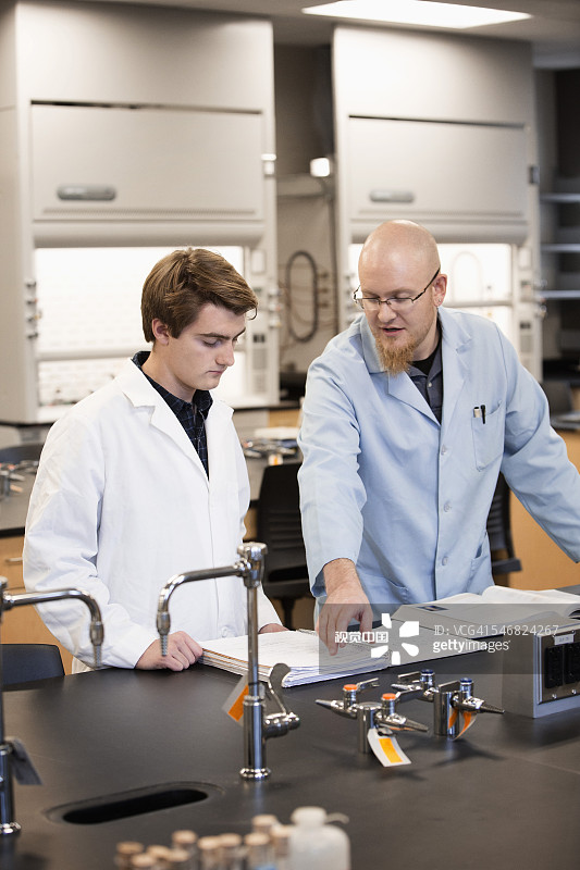 白人教师在科学实验室帮助学生图片素材