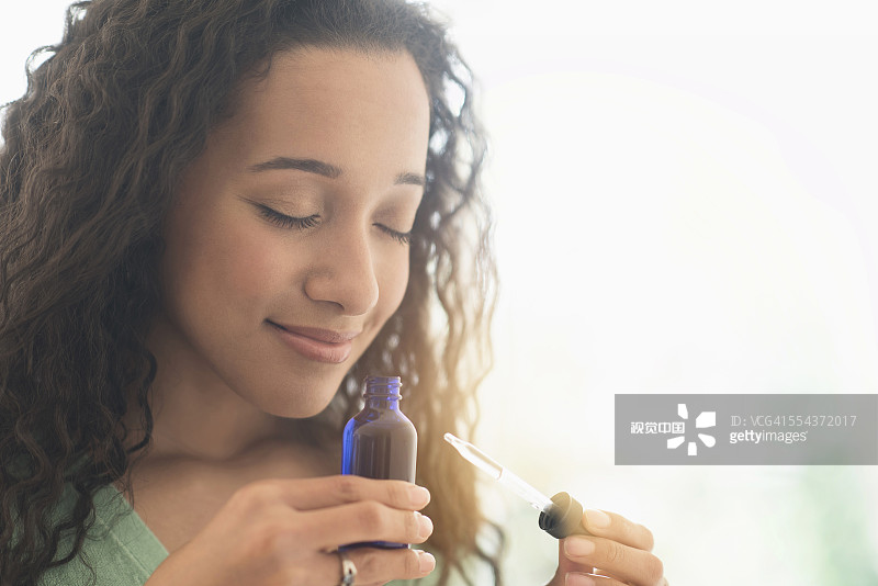 闻着香薰精油的混血女人特写图片素材