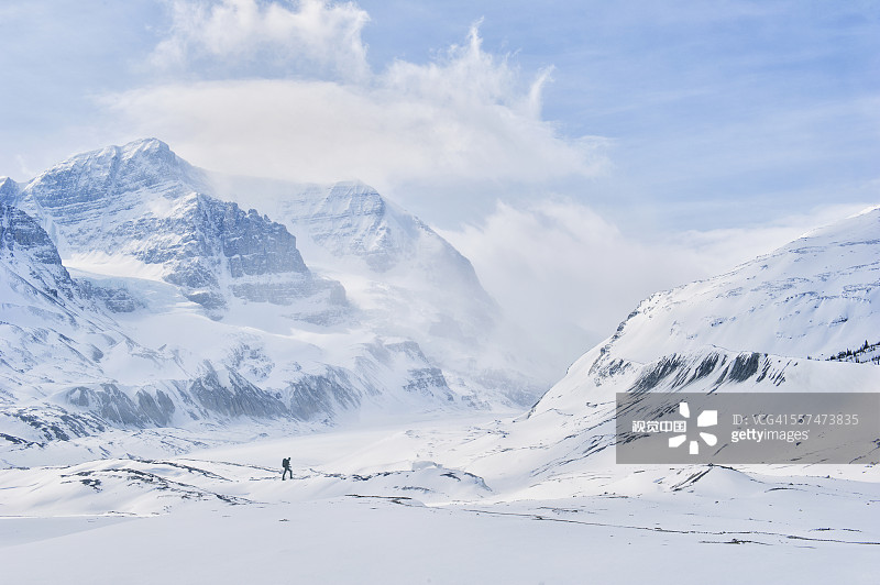 在雪山中行走的白人徒步旅行者图片素材