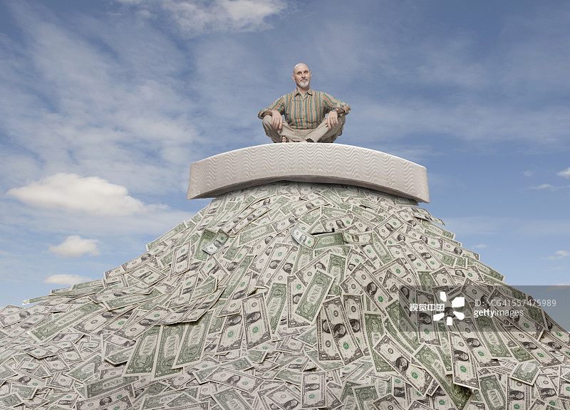 坐在钱堆上的白人商人图片素材