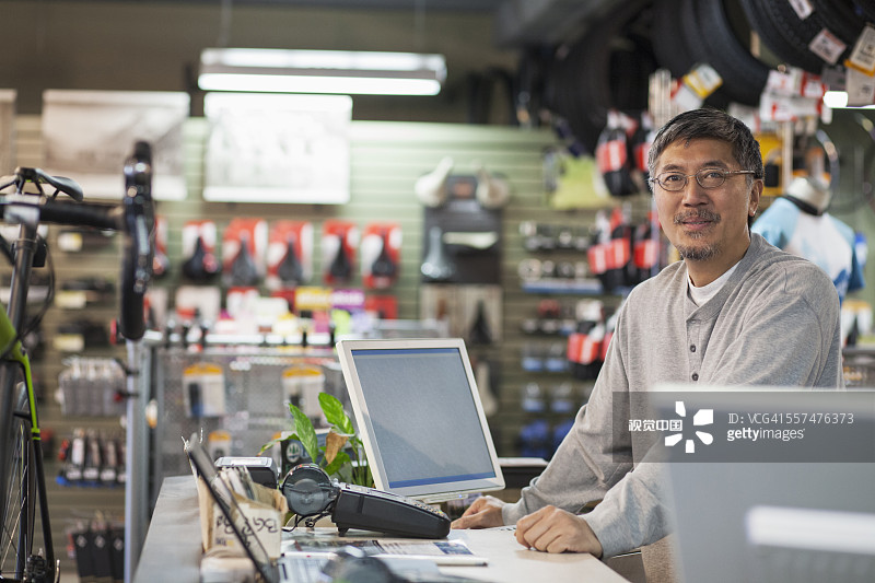 自行车店里微笑的太平洋岛民销售员图片素材