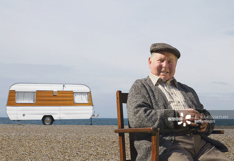 坐在海滩露营车外的白人男子图片素材
