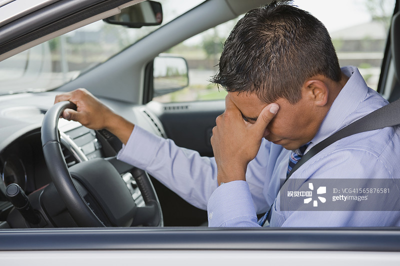 在交通中行驶的沮丧的西班牙裔商人图片素材