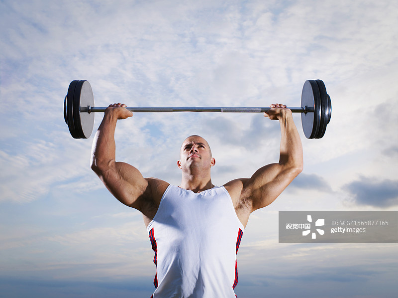 在阴天举重的混血运动员图片素材