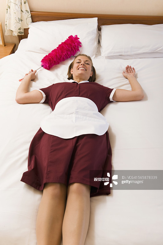 躺在酒店房间床上的白人女佣图片素材