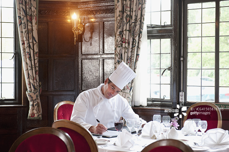 白人厨师在空餐厅准备菜单图片素材