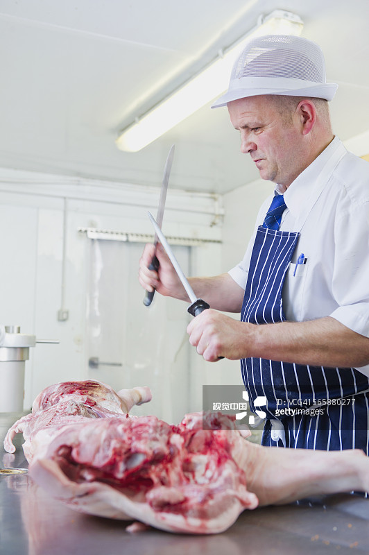 白人屠夫在店里磨刀图片素材