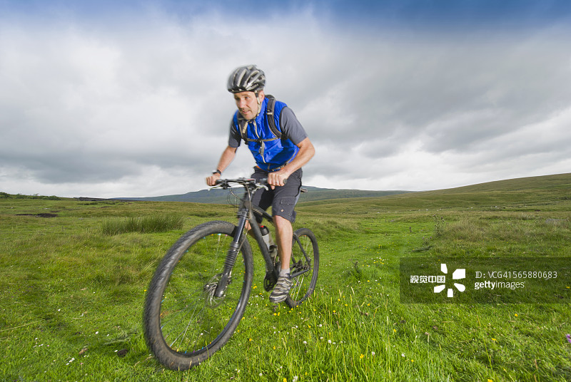 白人男子在乡村田野骑山地自行车图片素材