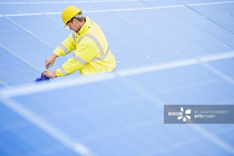 检查太阳能电池板的白人技术员图片素材