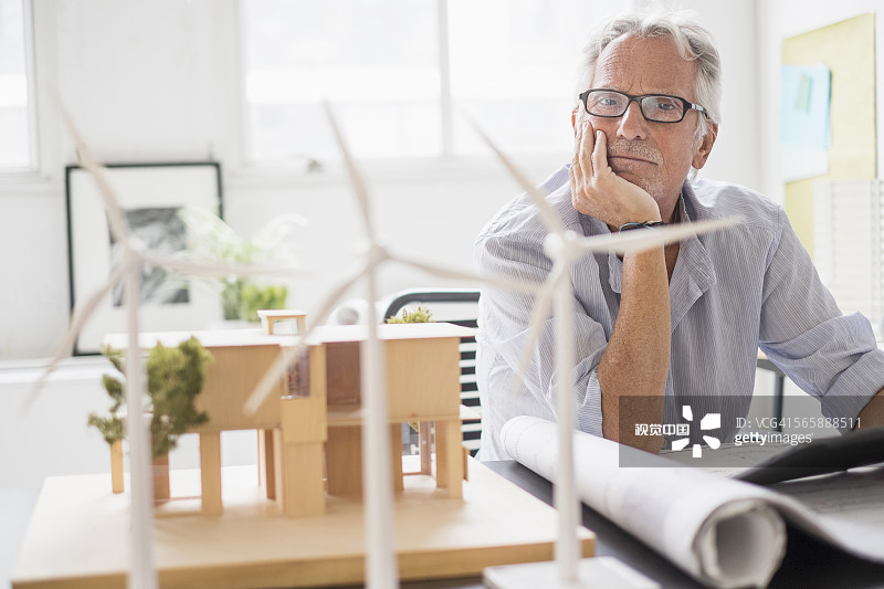 在办公室检查比例模型的年长的白人建筑师图片素材