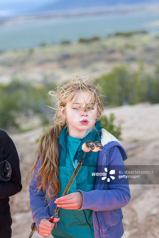 一个白人女孩在篝火上烤棉花糖图片素材