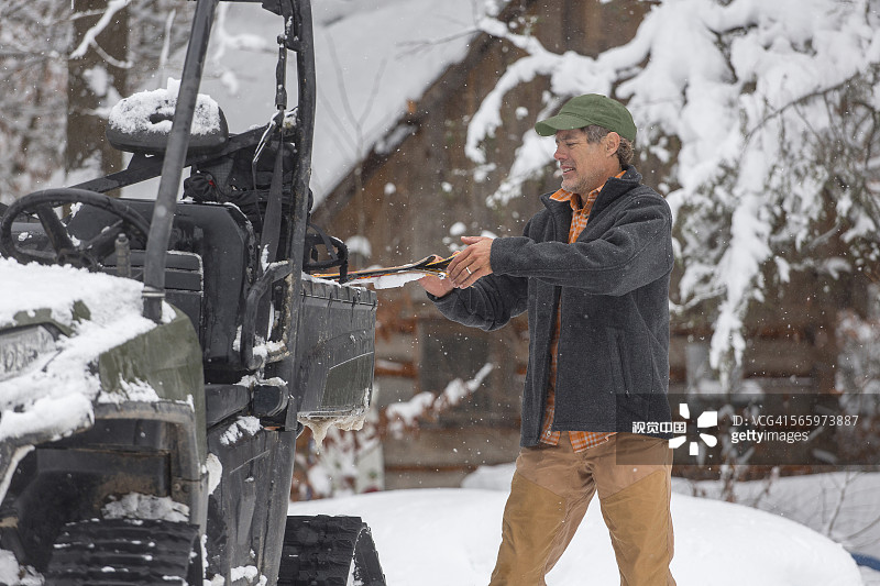 站在雪地车旁的混血儿图片素材