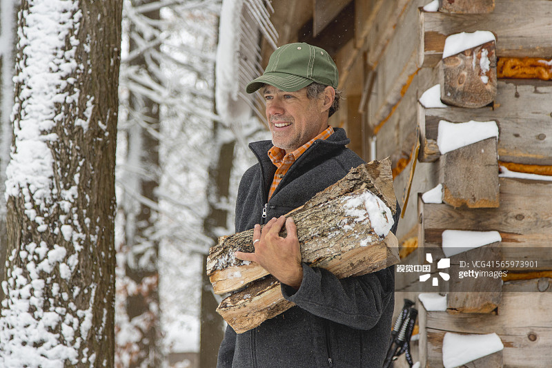 混血儿在雪棚附近扛着柴火图片素材