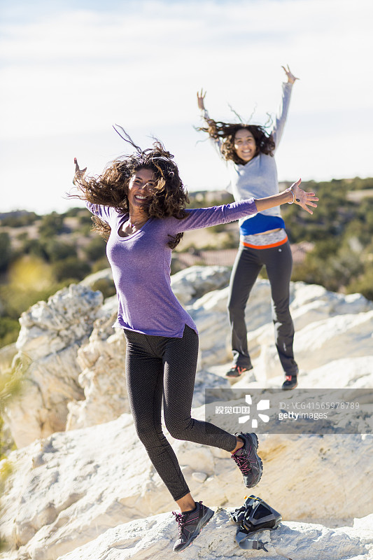 徒步者在岩石山顶上欢呼图片素材