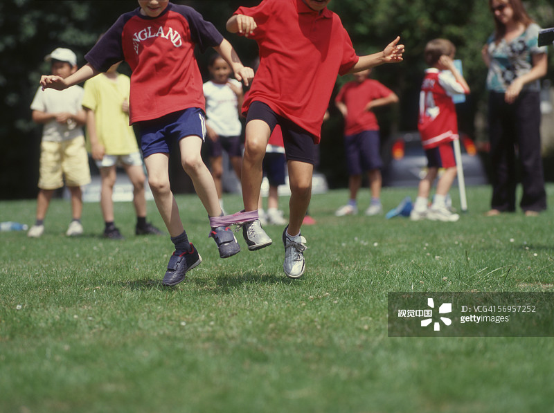 两个男孩参加三人绑腿赛跑图片素材
