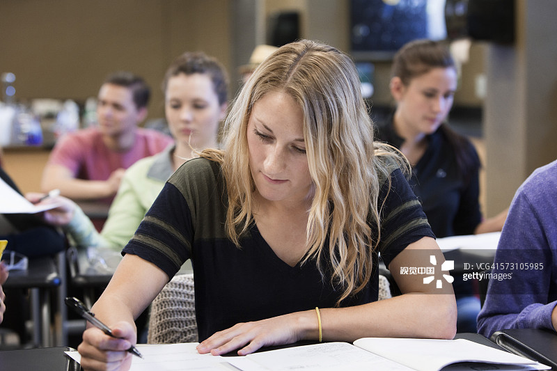 在教室书桌上写作的学生图片素材