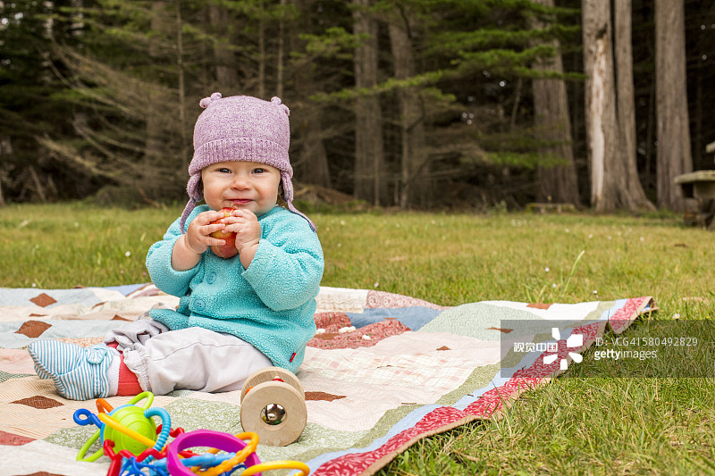 坐在草地毯子上的白人女婴图片素材