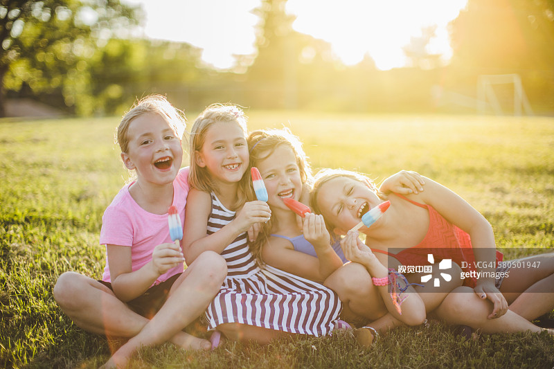 女孩在阳光明媚的田野里吃冰图片素材
