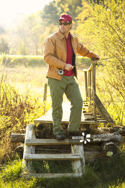 一个拿着鱼竿站在台阶上的白人图片素材