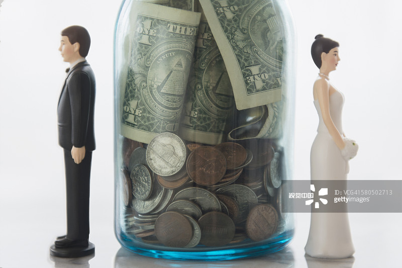 储蓄罐附近的新娘和新郎娃娃的特写图片素材