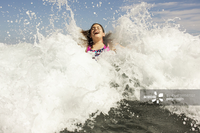 混血女孩在海浪中嬉戏图片素材