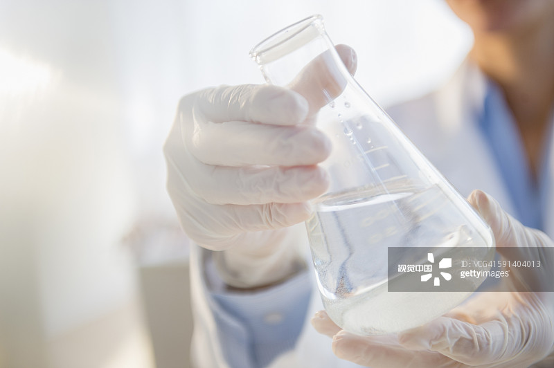 混血科学家在实验室里检查烧杯图片素材