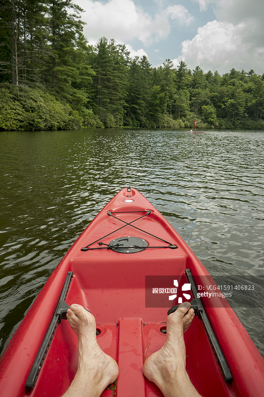 一个白人少年坐在湖上的独木舟里图片素材