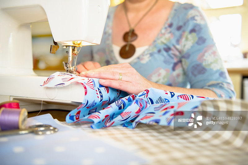 白人妇女用缝纫机图片素材