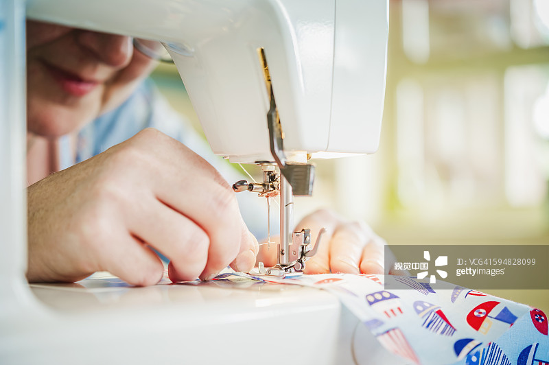 白人妇女用缝纫机图片素材