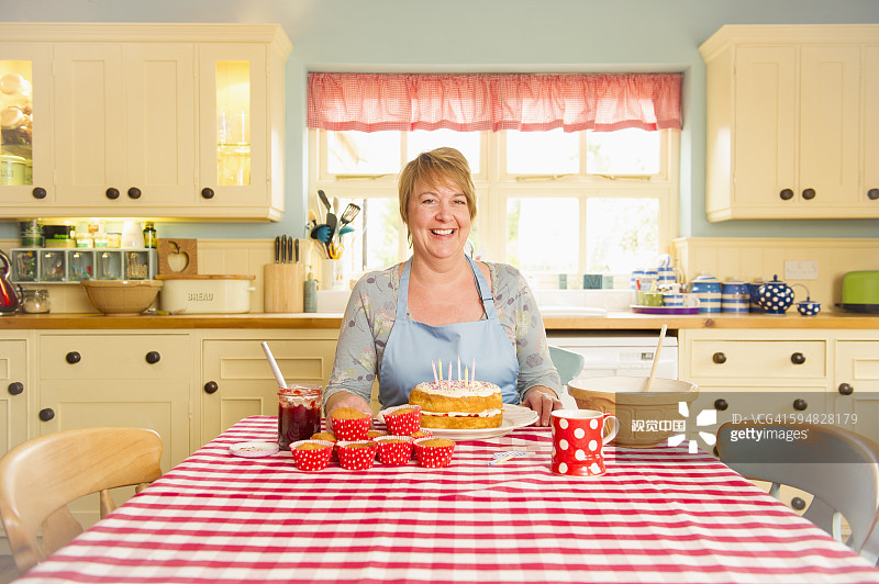 正在装饰生日蛋糕的白人妇女图片素材