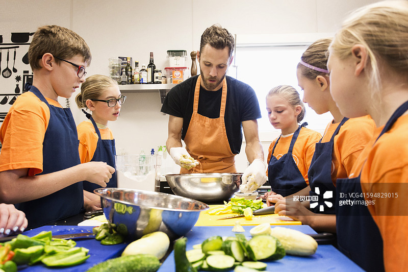 老师和学生在烹饪课上切菜图片素材