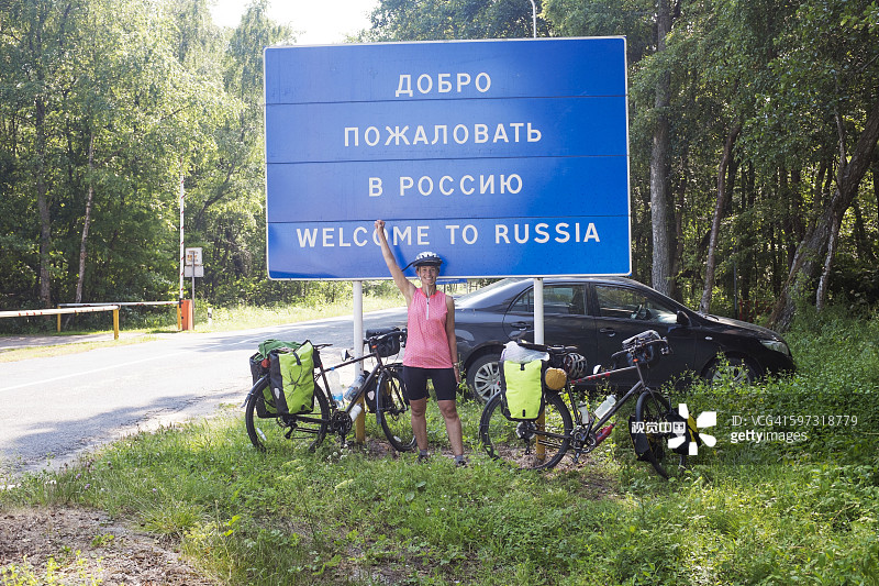 在俄罗斯边境欢呼的西班牙裔骑自行车的人图片素材
