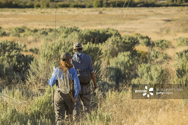 一对白种夫妇带着渔具在野外图片素材