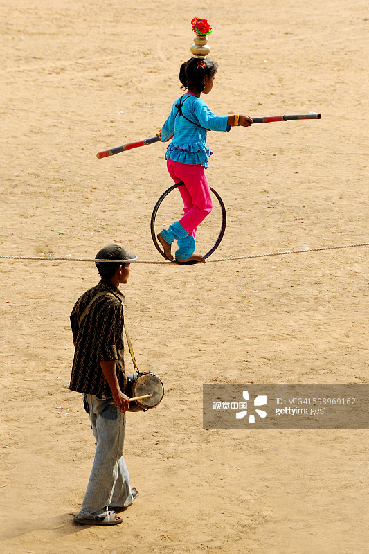 在印度拉贾斯坦邦普什卡集市上，女孩在绳子上表演杂技图片素材