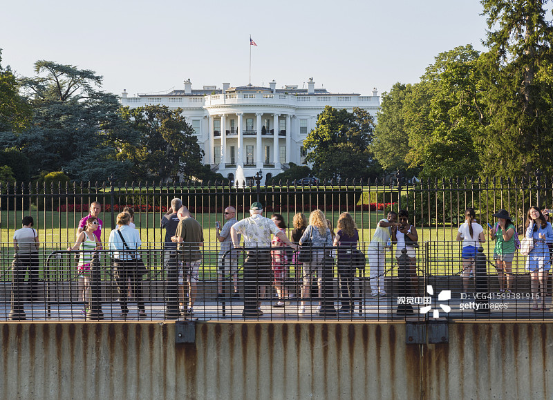 人群隔着栅栏和安全屏障观看美国华盛顿特区白宫南草坪的景色图片素材