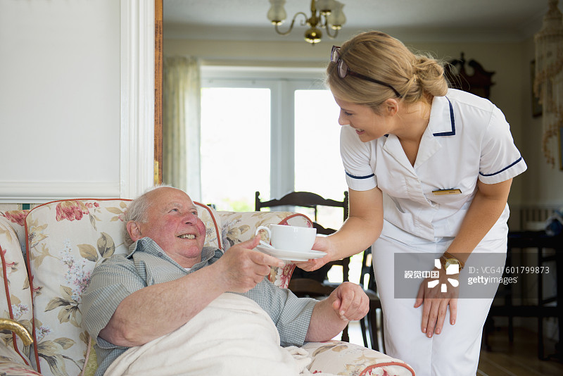 白人护士在家为病人倒茶图片素材